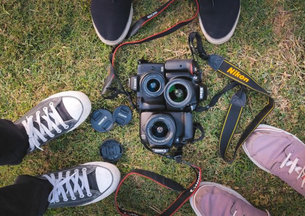 New Delhi, India -  March 24 2019: Three DSLRs of Nikon and Canon brand kept on green grass. These two are the most common and trusted companies in terms of DSLRs.